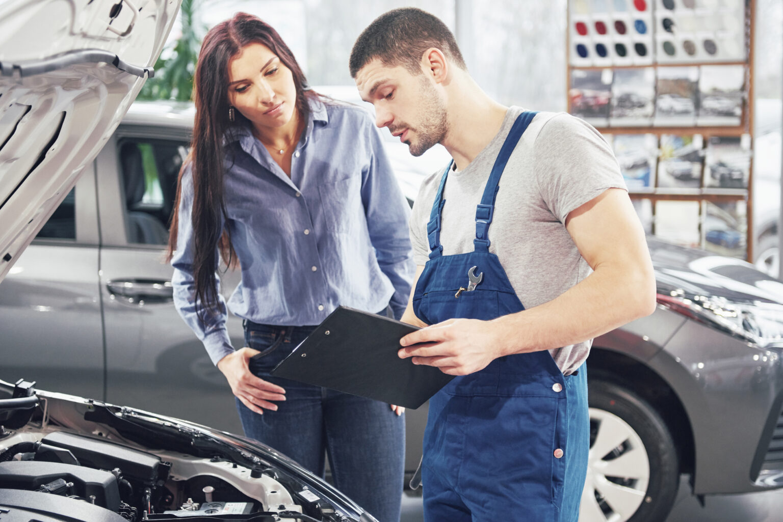a man mechanic and woman customer discussing repairs done to her vehicle